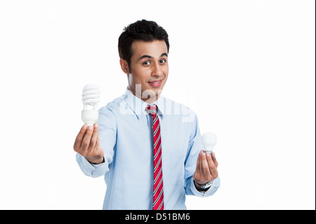 Vergleicht man eine Glühbirne mit einer Energie effiziente Glühbirne Geschäftsmann Stockfoto
