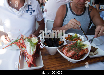 Menschen genießen eine Fischplatte im Restaurant in Waterfront, Cape Town - Südafrika Stockfoto
