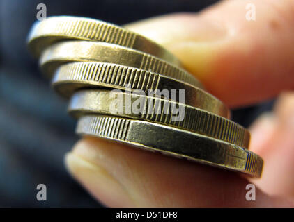 (Datei) - Münzen ein Dpa-Datei-Bild vom 26. September 2010 zeigt eine Person kneifen einen Euro zwischen zwei Fingern in Berlin, Deutschland. Die umstrittenen Änderungen an Wohlergehen Gesetz "Hartz-IV" sollen Wirklichkeit werden. Foto: Franz-Peter Tschauner Stockfoto