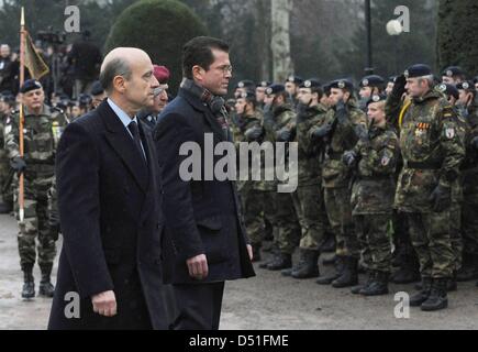 Französische Verteidigung Außenminister Alain Juppé (L) und German Defence Minister Karl-Theodor Zu Guttenberg gehen vorbei an deutschen Truppen der deutsch-französischen Brigade in Straßburg, Frankreich, 10. Dezember 2010. 600 deutsche Soldaten der deutsch-französischen Brigade werden im französischen Illkirch-Graffenstaden stationiert zu bekommen. Foto: MARIJAN MURAT Stockfoto