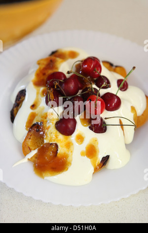 Gegrillte Pfirsiche mit Zabaione Dessert mit Kirschen und Marmelade Stockfoto