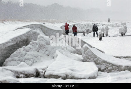 Kinderwagen zu Fuß passieren m hohe Barrieren aus Eis und Schnee im baltischen Seasside Resort in Zingst, Deutschland, 27. Dezember 2010. Eine Mischung aus starken Frost, Wind, Schnee und Eis haben eine bizarre Winterlandschaft geschaffen. Foto: Bernd Wuestneck Stockfoto