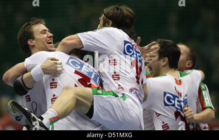 Magdeburger Spieler (L-R) Kjell Landsberg, Jure Natek und Fabian van Olphen feiern nach dem Handball-Bundesliga-Spiel zwischen SC Magdeburg und SG Flensburg-Handewitt in Magdeburg, Deutschland, 29. Dezember 2010. SC Magdeburg gewann das Spiel 34-29. Foto: Jens Wolf Stockfoto