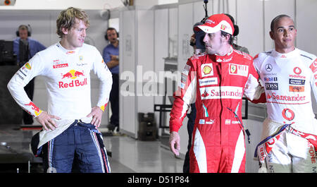 Deutschen Fahrer Sebastian Vettel von Red Bull steht zusammen mit Ferrari Fernando Alonso aus Spanien (L-R) und Mc Laren Mercedes' Lewis Hamilton aus England und nach der Qualifikation zum großen Preis von Singapur in Singapur, 25. September 2010. Alonso startet von der Pole-Position. Das Singapur Grand Prix Formel1 Rennen findet am 26. September am Marina Bay Street begründeten Stockfoto