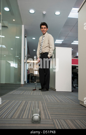 Geschäftsmann, Golfen im Büro Stockfoto