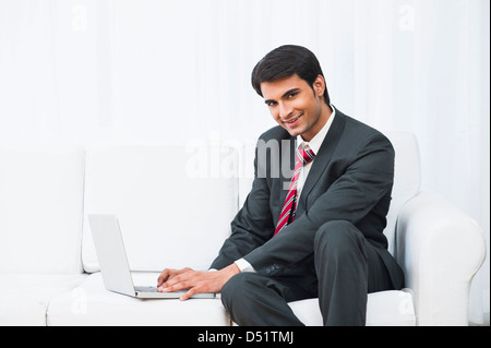 Geschäftsmann mit einem Laptop und lächelnd Stockfoto