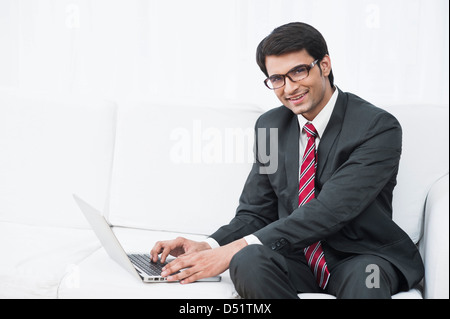 Geschäftsmann mit einem Laptop und lächelnd Stockfoto