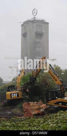 Polizei in Kampfmontur bewachen ein Holzfäller hacken einen Baum am Schlossgarden in Stuttgart, Deutschland, 1. Oktober 2010. Die gewalkt Baum bildet Teil einiger 300 Bäume, die im Rahmen der stark umstrittenen 4,1 Milliarden-Euro-Projekt gefällt werden ' Stuttgart 21', die eine Transformation der Stuttgarter Hauptbahnhof von einem oberirdischen Endstation für eine unterirdische durch Stati sieht Stockfoto