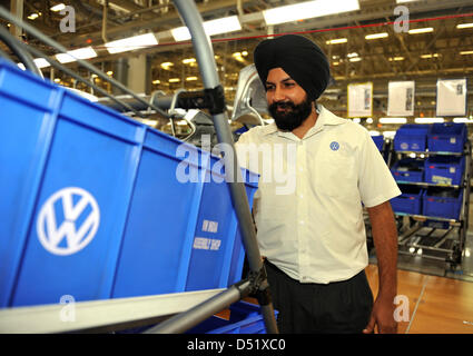 Ein indische Arbeiter untersucht eine Kiste voller Ersatzteile im Volkswagenwerk in Pune, Indien, 2. Oktober 2010. Der Premierminister der Landeshauptstadt von Niedersachsen, David McAllister, hat die erste Volkswagen Berufsausbildung Academy in Indien zusammen mit dem Vorsitzenden des Vorstands der Volkswagen AG, Martin Winterkorn eingeweiht. Foto: Marco Hadem Stockfoto