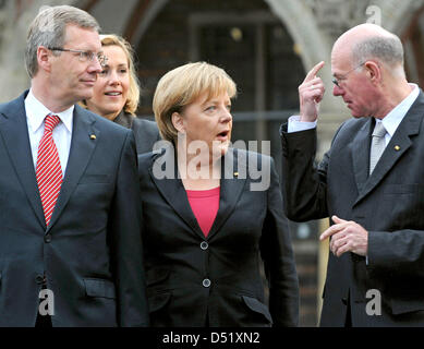 Deutsche Bundeskanzlerin Angela Merkel (M) kommt zur Feier "20 Jahre deutsche Einheit" deutsche Präsident Christian Wulff (L), seine Frau Bettina sowie den Präsidenten des Deutschen Bundestages Norbert Lammert vor dem Rathaus in Bremen, Deutschland, 3. Oktober 2010. Bremen ist dieses Jahr Gastgeber für die Jubiläumsfeier zum Tag der deutschen Einheit, weil es aktuelle Stockfoto