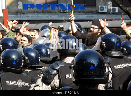 Polizisten versuchen, Weg Extremisten, schieben Sie die Führung von einem geistlichen ein Kreuz haltend, während der erste Gay Pride Parade in Belgrad, Zentralserbien, 10. Oktober 2010 sind. Hunderte von Schwulen, Lesben und Unterstützer der Parade, auch Einheimische und ausländische Beamte, versammelt im Manjez Park für den kurzen Marsch durch drei nahe gelegenen Straßen. Vor, während und nach dem kurzen Marsch, Stockfoto