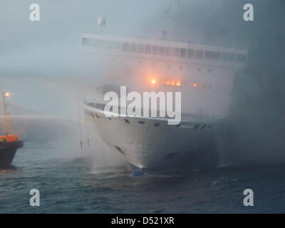 Ein Sok/Havariekommando Handout Bild datiert 10. Oktober 2010 Funktionen deutsche Schlepper "Fairplay 26", wie es spritzt Wasser auf der brennenden Fähre "Lisco Gloria", die in der Ostsee auf der dänischen Insel Langeland verankert ist. Die Ro-Ro-Fracht und Passagier-Schiff "Lisco Gloria, arbeiten unter litauischer Flagge und mit rund 240 Menschen an Bord am 09 Oktober nach Feuer fing ein Stockfoto