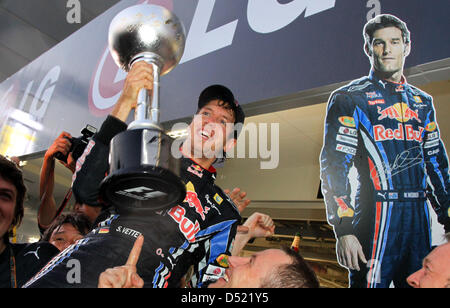 Deutsche Formel-1-Fahrer Sebastian Vettel (C) von Team Red Bull feiert mit seinem Team nach dem Gewinn des Grand Prix von Japan auf dem Suzuka Circuit in Suzuka, Japan, 10. Oktober 2010. Vettel gewinnt vor seinem Teamkollegen australische Pilot Mark Webber, im zweiten und spanische kam, Fahrer Fernando Alonso Ferrari-Team. Foto: Jens Büttner Stockfoto