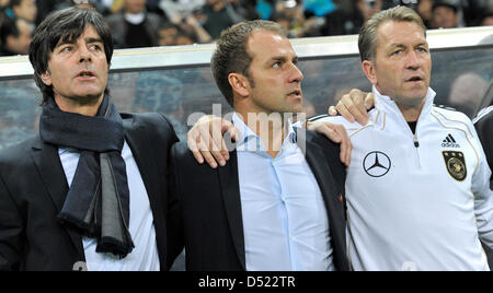 Deutschlands Bundestrainer Joachim Loew (L-R), Co-Trainer Hans-Dieter Flick und Torwarttrainer Andreas Köpke die Nationalhymne vor der UEFA Euro 2012-Gruppe A-Qualifikation Kasachstan Vs Deutschland in Astana, Kasachstan, 12. Oktober 2010 singen. Die deutsche Mannschaft gewann mit 3: 0. Foto: Marius Becker Stockfoto