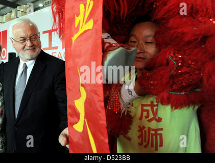 Ministerpräsident des Landes Schleswig-Holstein Peter Harry Carstensen steht neben einem "tanzenden Drachen" während der Eröffnungsfeier der Unternehmensgruppe ACO aus Rendsburg in Shanghai, China, 14. Oktober 2010. Carstensen wird die EXPO in Shanghai besuchen, mit seinen wirtschaftlichen delegatin am letzten Tag seiner einwöchigen Reise. Foto: Carsten Rehder Stockfoto