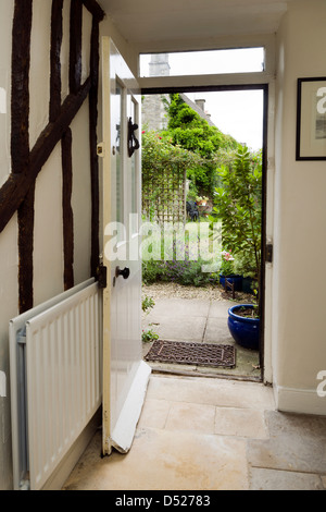 Eine offene Tür für einen Zeitraum cottage Suchen von innen heraus auf einen Garten. Stockfoto