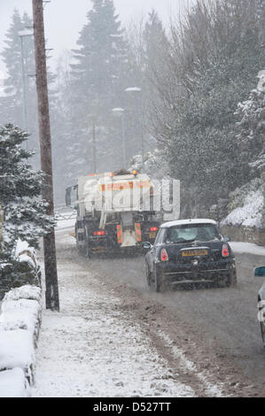 Es ist ein starker Schnee während der Zauber der kalten, schneereichen Winter Wetter & Rat Streuer Kombi (mit Schneepflug) ist entlang fahren, Clearing Hauptstraße durch Dorf, Verbreitung von Steinsalz auf slippy Oberfläche - Hawksworth, West Yorkshire, England, UK. Stockfoto