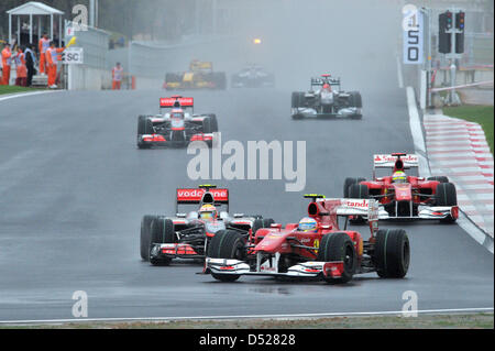 Spanische Fahrer Fernando Alonso Ferrari (M) fährt mit seinem Auto vor britischen Fahrer Lewis Hamilton von McLaren Mercedes (L) und Alonsos Team Mate brasilianischen Felipe Massa (R) während des Rennens auf Korea International Circuit in Yeongam, Südkorea, 24. Oktober 2010. Fernando Alonso Ferrari gewann das erste chaotische Formel1 Rennen in Korea vor Hamilton von McLaren und Massa F Stockfoto