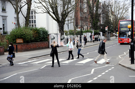 Touristen gehen über den berühmten Fußgängerzone Zebrastreifen in Abbey Road St John's Wood London berühmt geworden durch die Beatles Stockfoto