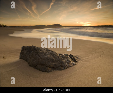 Sonnenuntergang am Strand mit Felsen im Vordergrund. Das Foto ist in Valdoviño, Galicien, Spanien Stockfoto