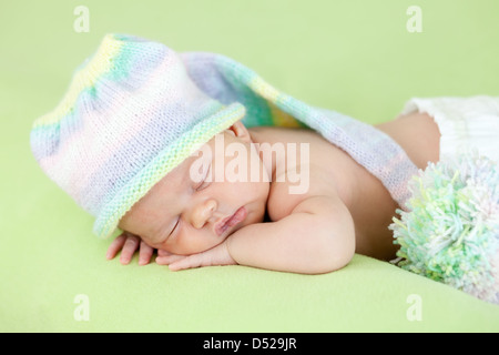 entzückende Baby weared Kappe auf Bauch schlafen Stockfoto