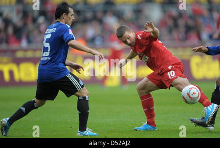 Kölner Lukas Podolski (R) und Hamburger Piotr Trochowski vie für der Ball beim Bundesliga Spiel FC Köln vs. Hamburger SV an der RhineEnergyStadium in Köln, 30. Oktober 2010 Foto: Federico Gambarini Stockfoto