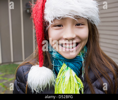 Gemischte Rassen Mädchen in geschweiften Klammern Santa Hut Stockfoto