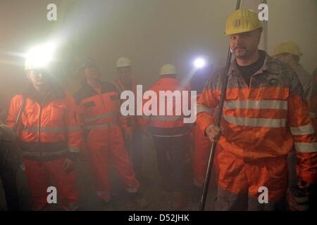 Bergleute mit Fackeln stehen in den Staub, verursacht durch den Tunnel Durchbruch des "Bibratunnel" in Saubach, Deutschland, 3. März 2010. Mit dem Durchbruch Zeremonien für die "Bibratunnel" und die benachbarte "Finnetunnel" staatliche Bundesbahn Deutsche Bahn AG feierte Halbzeit beim Bau seiner neuen Highspeed-Schienenverbindung zwischen Erfurt, Halle und Leipzig. Die Stockfoto