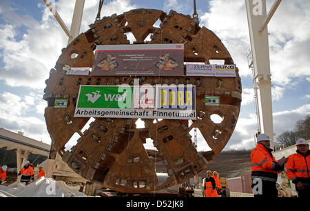 Bergleute enthüllen das Schneidrad während der Tunnel-Durchbruch-Zeremonie auf der "Bibratunnel" in Saubach, Deutschland, 3. März 2010. Mit dem Durchbruch Zeremonien für die "Bibratunnel" und die benachbarte "Finnetunnel" staatliche Bundesbahn Deutsche Bahn AG feierte Halbzeit beim Bau seiner neuen Highspeed-Schienenverbindung zwischen Erfurt, Halle und Leipzig. Die Stockfoto