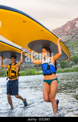 Hispanische Paare tragen Paddel-im Wasser Stockfoto