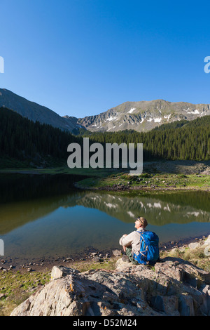 Kaukasische Wanderer auf Fels sitzend Stockfoto