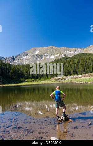 Kaukasische Wanderer stehen auf Felsen in See Stockfoto