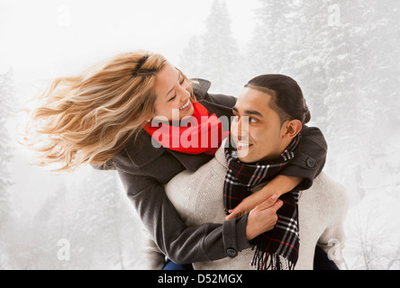Lächelnde paar umarmt im Schnee Stockfoto