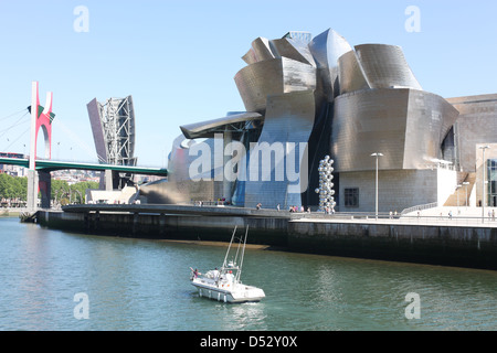 Ein Boot überquert den Fluss Nervion vor dem Guggenheim-Museum Stockfoto