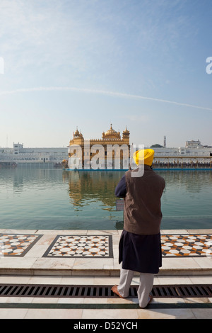 Ein Tempelwächter wacht über den herrlichen goldenen Tempel unter blauem Himmel in Amritsar Punjab, Indien Stockfoto