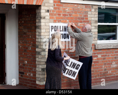 Zwei Wahllokal Angestellten setzen sich ein Hinweis Stockfoto