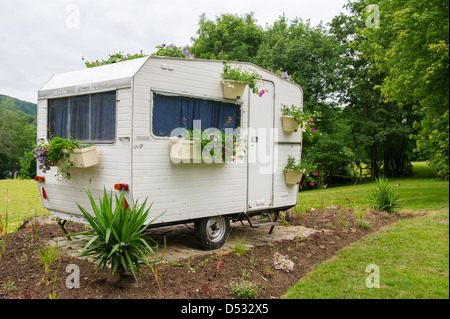 Alten Wohnwagen mit vielen hängenden Blumen in Töpfen Stockfoto