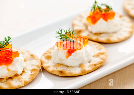 Nahaufnahme von Kaviar und Frischkäse Vorspeise auf Cracker Stockfoto