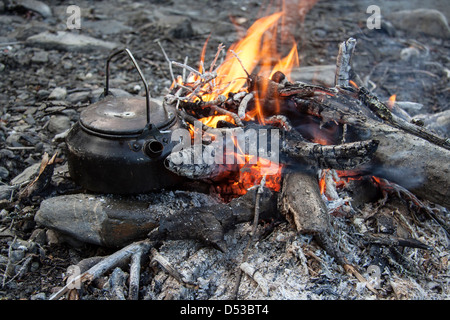 Lagerfeuer mit Wasserkocher auf Holz, das Hitze und Flammen einfängt. Stockfoto