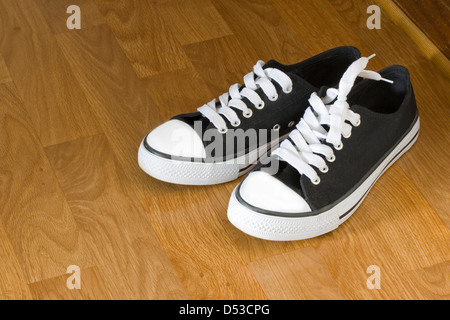 Klassische schwarze und weiße Turnschuhe holzähnliche Stock Stockfoto