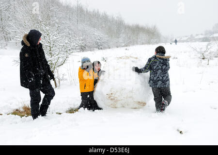 Hucknall, Notts, UK. 23. März 2013. Schnee ist weiterhin hinzufügen bereits tiefen Schnee fallen. Kinder machen große Schneeball. Bildnachweis: Ian Francis / Alamy Live News Stockfoto