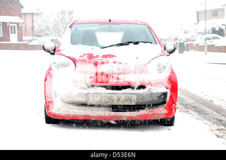 Hucknall, Notts, UK. 23. März 2013. Schnee ist weiterhin hinzufügen bereits tiefen Schnee fallen. Schneebedeckte rotes Auto. Bildnachweis: Ian Francis / Alamy Live News Stockfoto