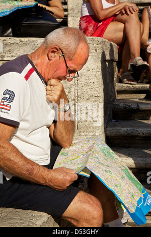 Tourist sitzt auf der Piazza di Spagna, tief in Gedanken und einen Blick auf einen Stadtplan von Rom. Rom, Italien Stockfoto