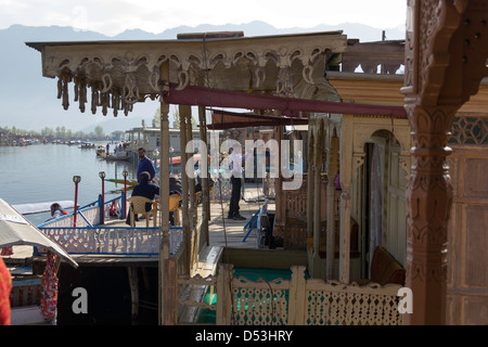 Touristen am vorderen Teil der Hausboote aufgereiht entlang der Ufer des Sees Dal in Srinagar, offene Plattform zur See zu sehen. Stockfoto