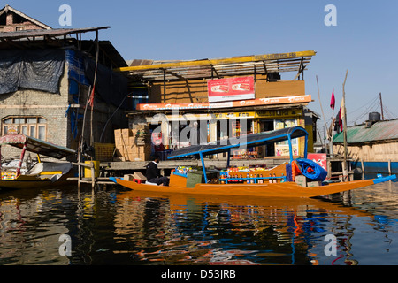Schwimmende Shop (Shikara) zusammen mit einem Shop auf Stelzen auf dem Wasser des Sees Dal in Srinagar, Bereitstellung von Hilfsgütern gebaut. Stockfoto
