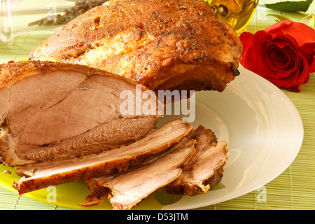 Gebratenes Schweinefleisch auf einem weißen Teller unter Gewürzen Stockfoto