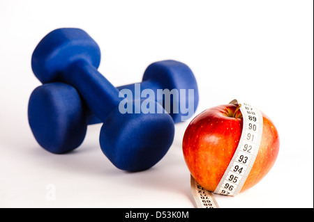 Blaue Hanteln und roter Apfel mit Maßband isoliert auf weißem Hintergrund Stockfoto