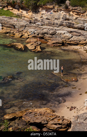 Einsamer Mann, der durch den Rand des Wassers, Gordons Bay Beach, Sydney, NSW, Australien Stockfoto