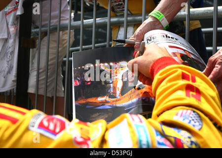 St. Petersburg, Florida, USA. 23. März 2013. IZOD IndyCar Treiber Ryan Hunter-Reay unterschreibt ein Autogramm für einen Fan auf seinem Weg zur Boxengasse vor Beginn des Qualifyings am Nachmittag. (Bild Kredit: Kredit: Luis Santana/Tampa Bay Times/ZUMAPRESS.com/Alamy Live-Nachrichten) Stockfoto