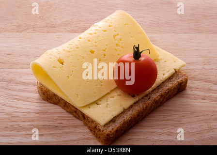 Open-Sandwich mit Käse und Tomaten auf einem Holzbrett Stockfoto